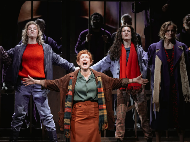 Peggy White sings with her arms flung wide, the ensemble behind her echoing the pose.