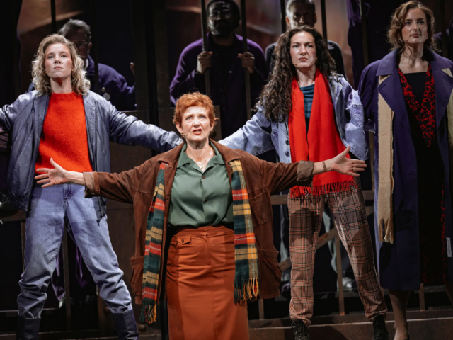 Peggy White, arms outstretched, leads the women of Wallsend in song.