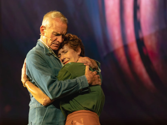 Jackie and Peggy White embrace, her face pressed to his shoulder.